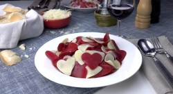 Ein Teller mit zweifarbiger Herzchenpasta als eines von drei Geschenken zum Valentinstag.