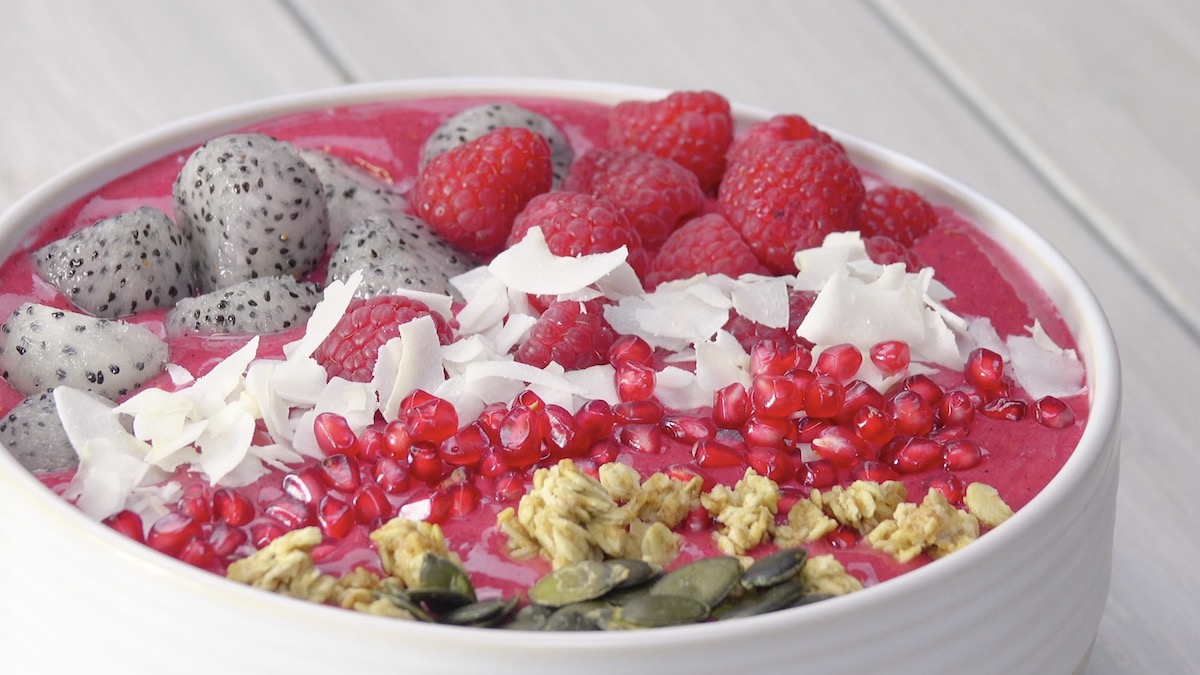 Smoothie-Bowl mit Himbeeren, Drachenfrucht, Granatapfelkernen, MÃ¼sli und KÃ¼rbiskernen