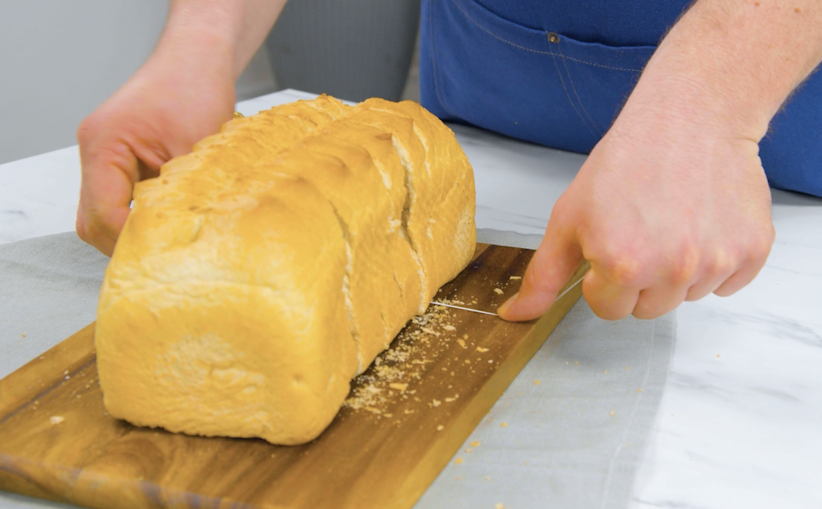 WeiÃŸbrot wird mit Zahnseide in Scheiben geschnitte