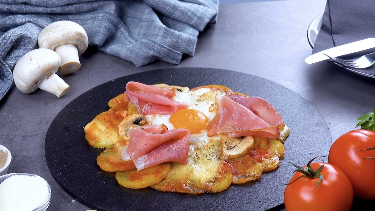 Pizza mit Kartoffeln, Schinken, Pilzen und Spiegelei