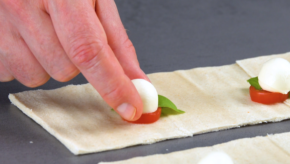 Toastbrot wird mit Tomaten und Mozzarella belegt