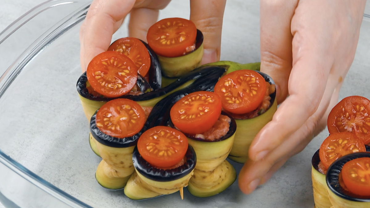 GefÃ¼llte Aubergine in Blumenform wird in Auflaufform gesetzt