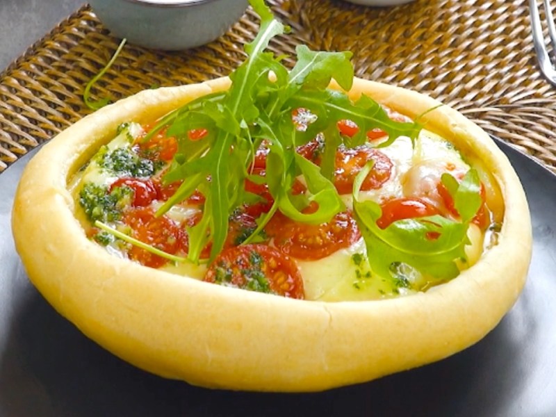 Ein Pizza Pot Pie mit Tomaten-Mozzarella-Füllung und frischem Rucola.