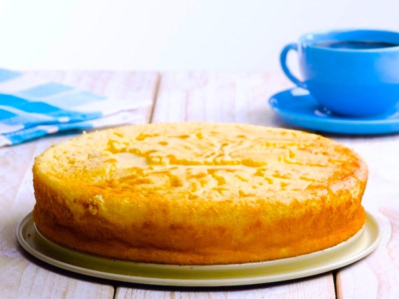 Kuchenplatte mit Käsekuchen mit flüssigem Kern und blauer Tasse