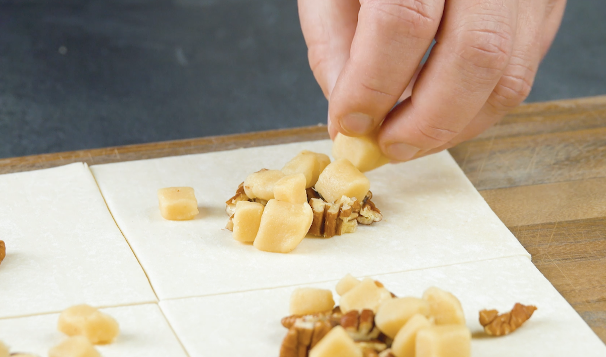 PekannÃ¼sse und Marzipan werden auf BlÃ¤tterteigvierecken verteilt