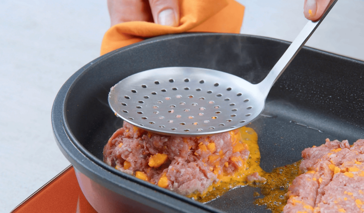 Hackfleisch mit Cheddar wird in Pfanne zu Burger-Patty geformt