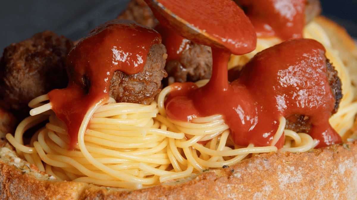 Tomatensauce wird Ã¼ber hackbÃ¤llchen gegeben