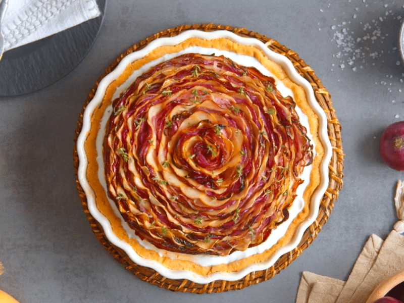 Zwiebelkuchen mit Mürbeteig, serviert in einer Tarteform.