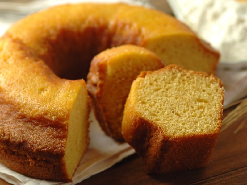 Ein runder Becherkuchen aus dem mehrere Stücke herausgeschnitten wurden.