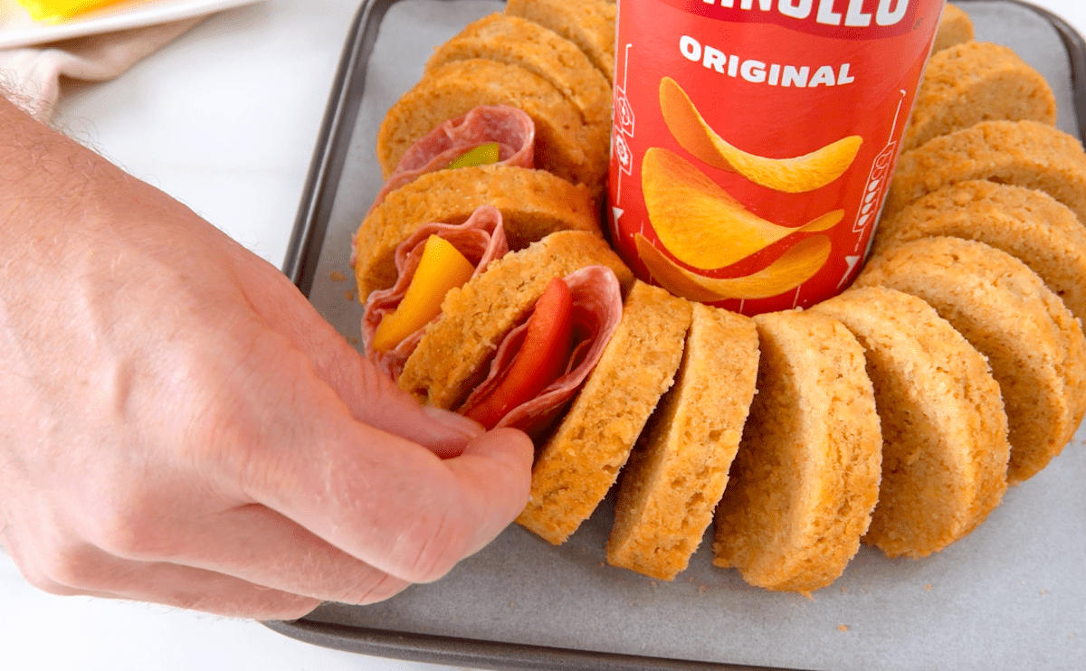 In Salami eingewickelte Paprika wird in eine Brot gesteckt