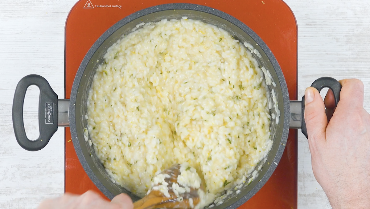 Risotto in Topf wird mit HolzlÃ¶ffel umgerÃ¼hrt