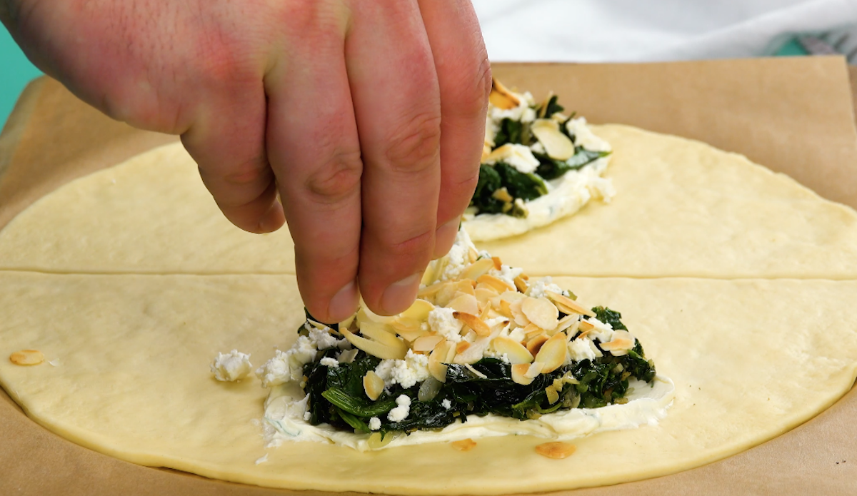 GerÃ¶stete MandelblÃ¤ttchen werden Ã¼ber Feta verteilt.