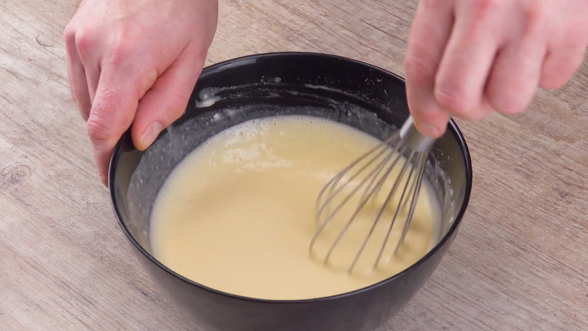 Pfannkuchenteig wird mit Schneebesen in einer SchÃ¼ssel angerÃ¼hrt 