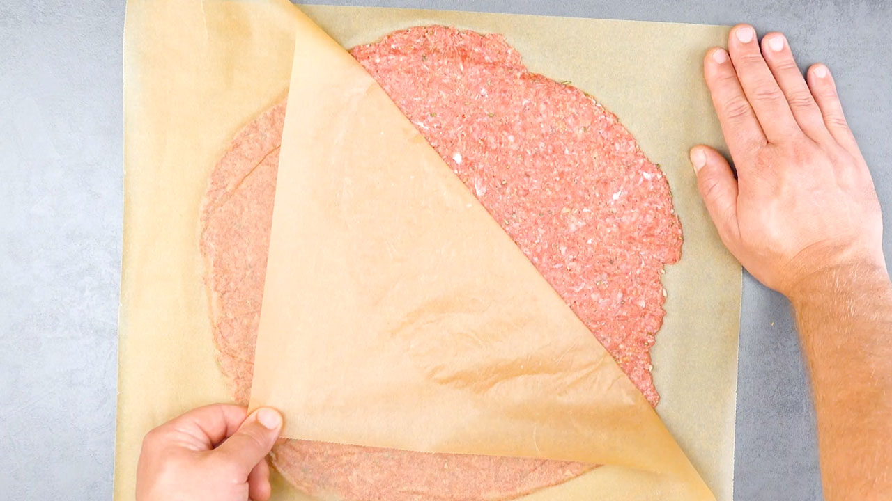 Backpapier wird von Hackfleisch abgezogen