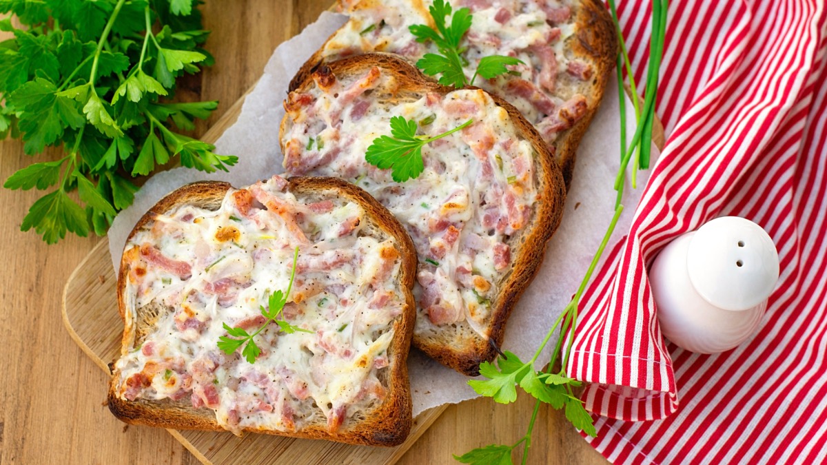 Mehrere Flammkuchen-Toasts, die halb übereinander liegen.