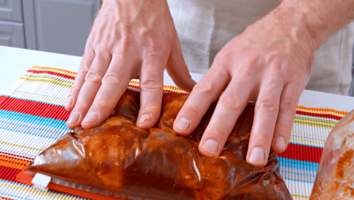 HÃ¤hnchenschenkel werden in einem Ziplock-Beutel mariniert