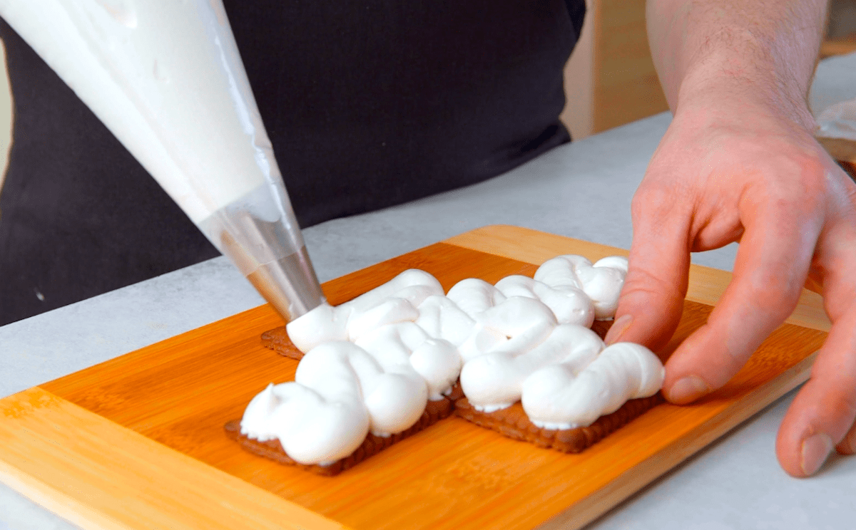 FrischkÃ¤secreme wird mit einer SpritztÃ¼lle auf Butterkeksen verteilt.