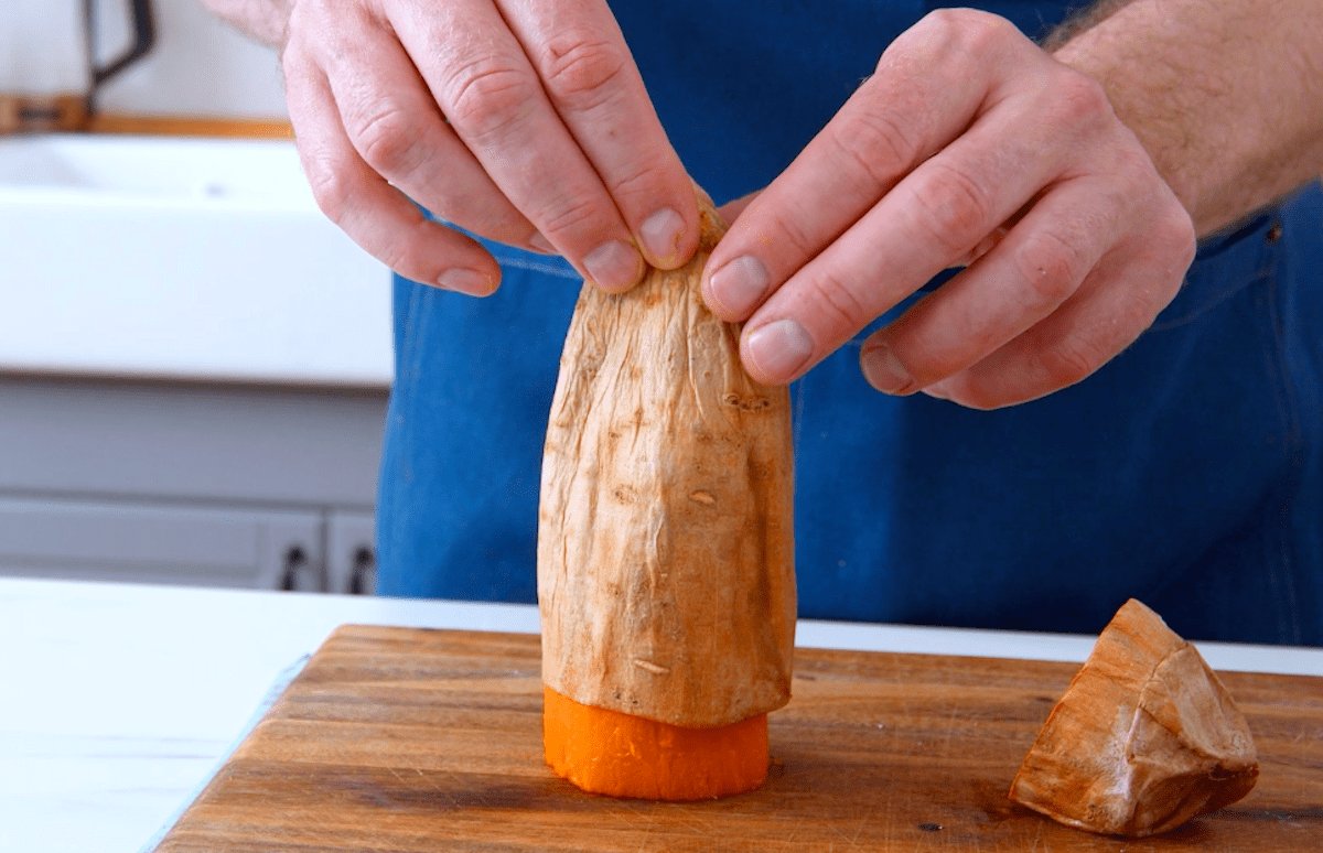 Die Schale einer gebackenen SÃ¼ÃŸkartoffel wird abgezogen