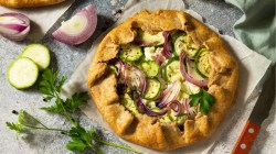 Zucchini-Galette mit Zwiebel und Feta auf einen Brett