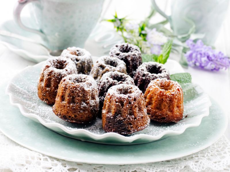 Mini-Lebkuchen-Gugelhupf, serviert auf einem Teller, bestäubt mit Puderzucker.