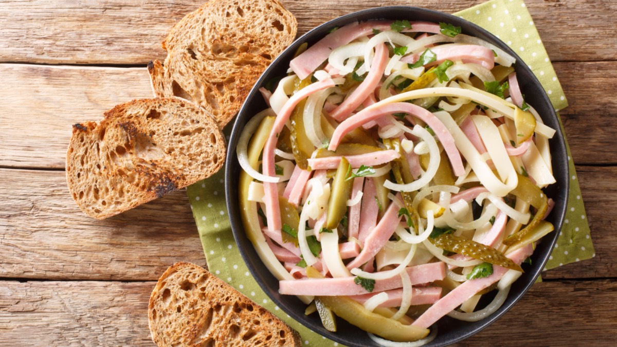 Eine SchÃ¼ssel Schweizer Wurstsalat mit gerÃ¶steten Brotscheiben