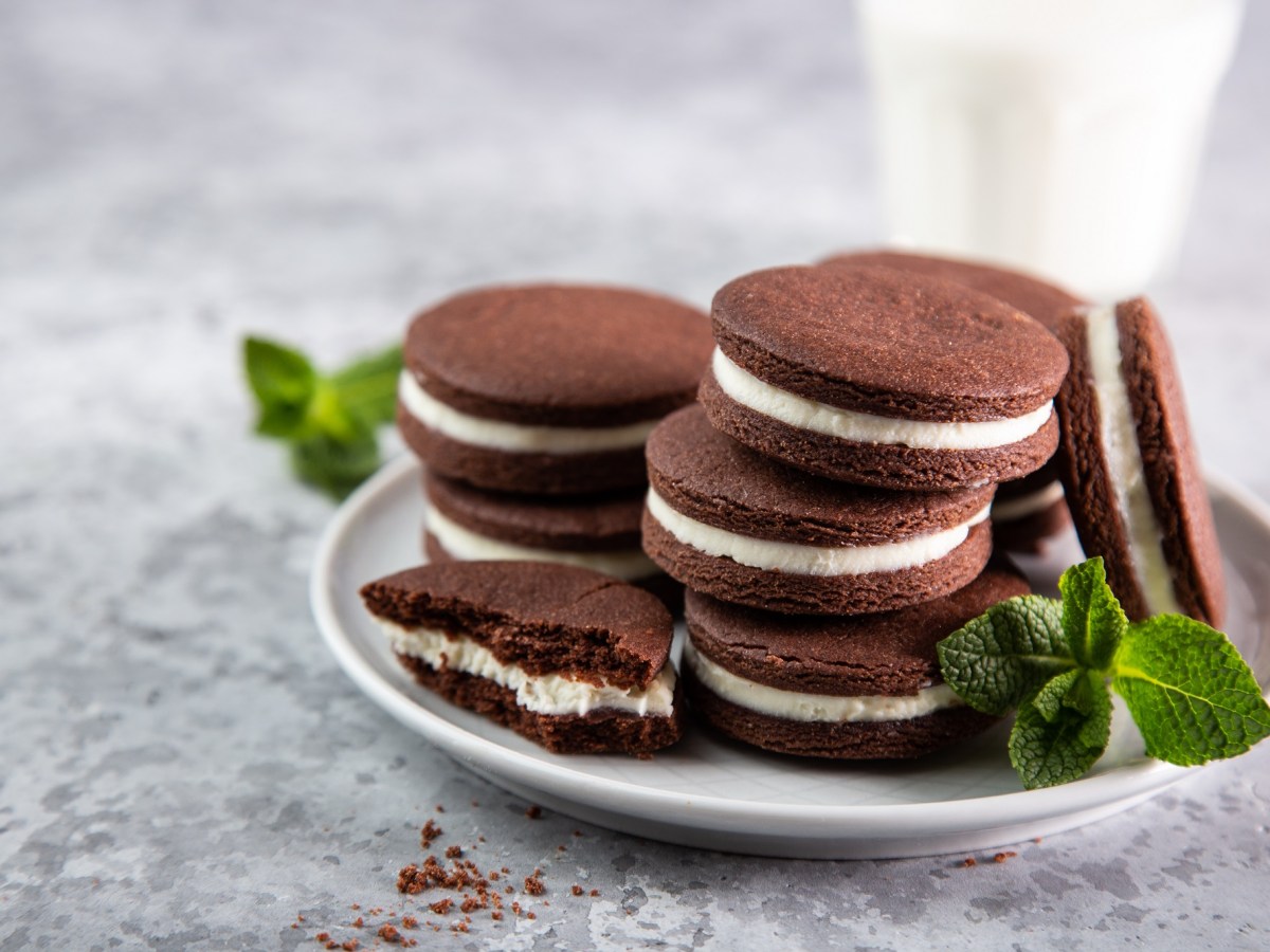 Ein Teller selbst gemachte Oreos mit einem Glas Milch im Hintergrund.