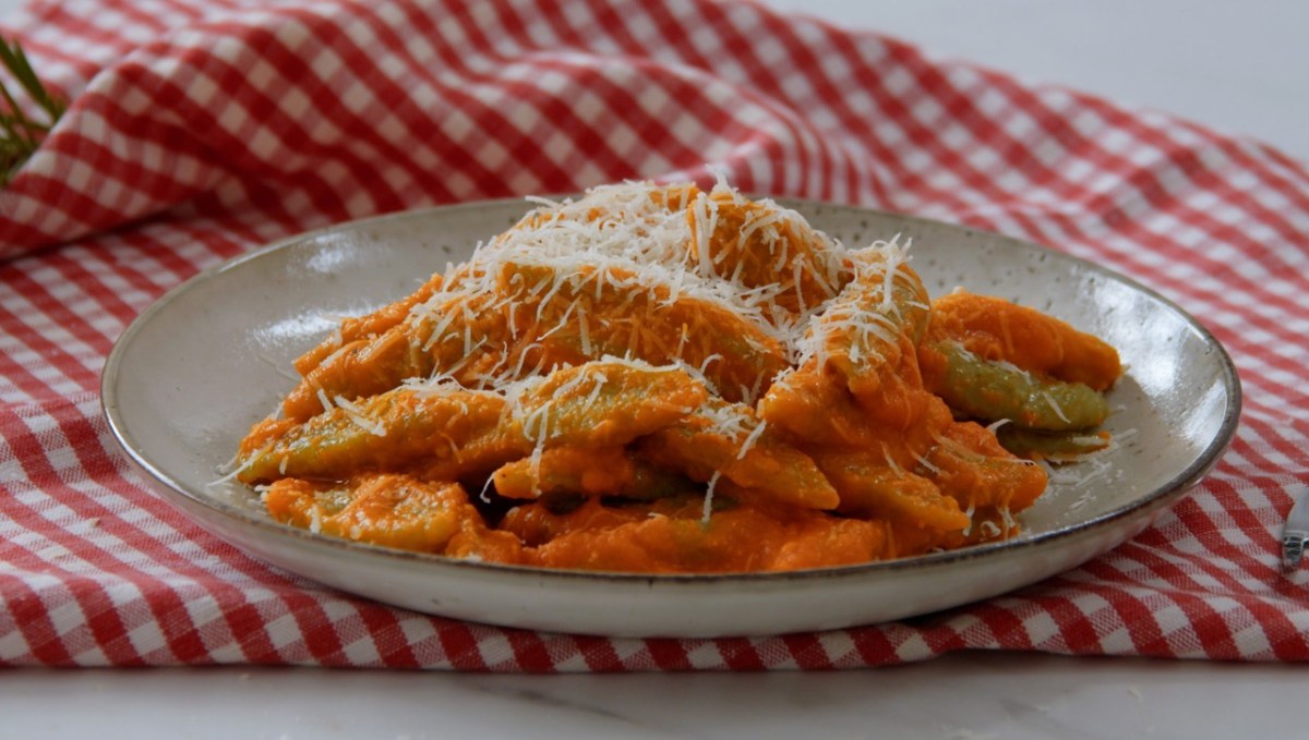 Eine Portion Brokkoli-Schupfnudeln mit geriebenem Parmesan auf einem Teller.