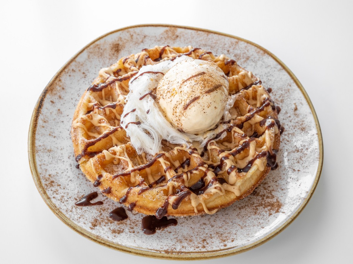 Churros-Waffel mit Eis und Schokoladenglasur auf einem hellen Teller