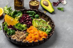 Fitnessbowl mit Quinoa, Süßkartoffeln, Avocado, Salat und Bohnen.