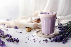 Tasse mit lilafarbenem Getränk und getrocknetem Lavendel