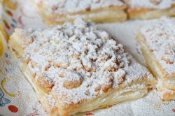 Prasselkuchen-Rezept: Ein Stück Prasselkuchen mit Streuseln und Puderzucker, Nahaufnahme.