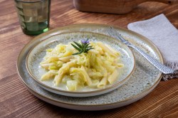 Teller mit einer Portion Wirsing-Pasta auf einem Tisch.