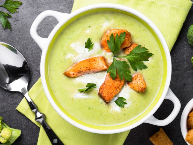 Eine Schüssel Brokkolisuppe mit Lachs in der Draufsicht.