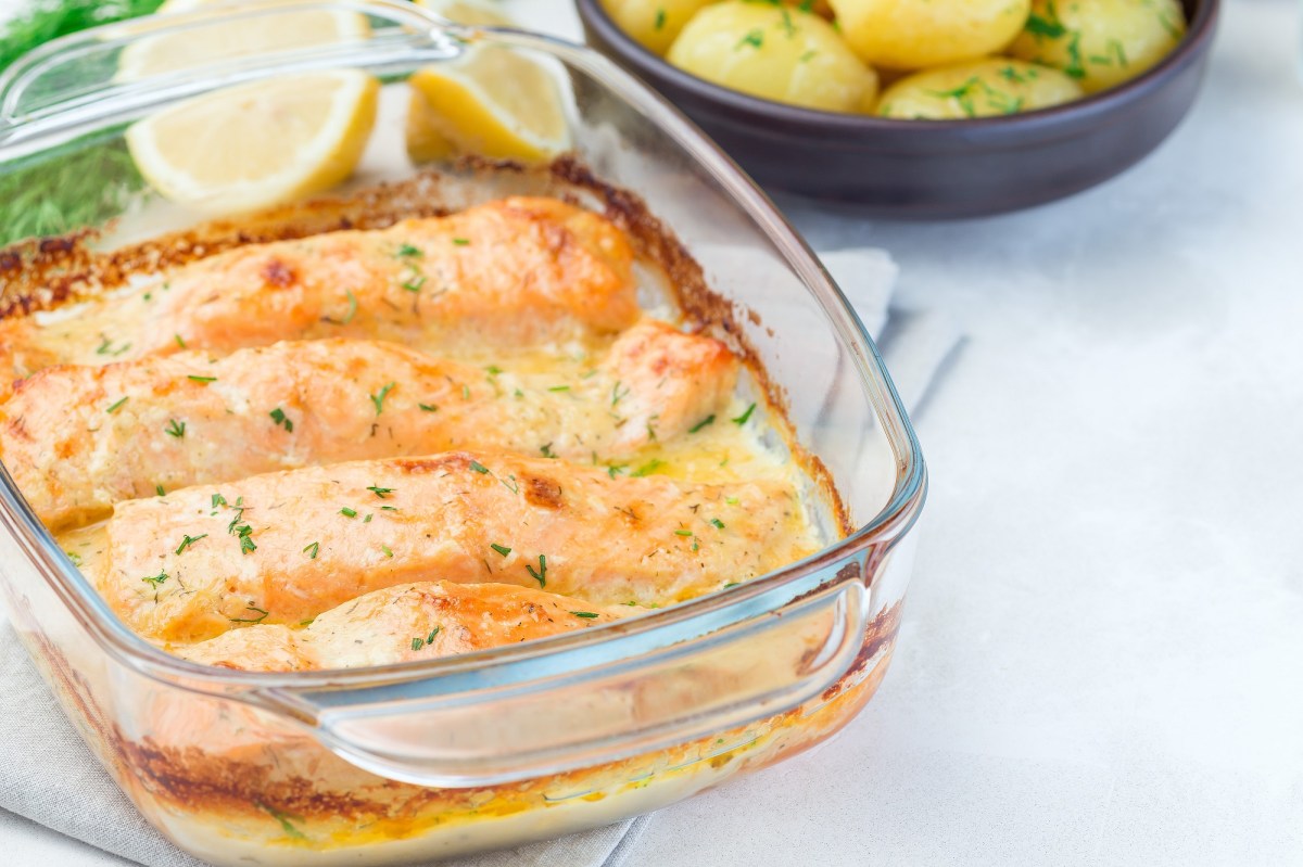 Auflaufform mit Lachs-Sahne-Gratin auf hellem Untergrund