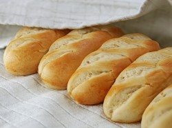 Milchbrötchen selber machen: Milchbrötchen auf einer weißen Unterlage bedeckt von einem weißen Tuch.