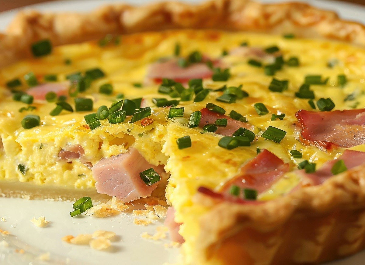 Angeschnittene Oster-Quiche mit Schinken und Ei.