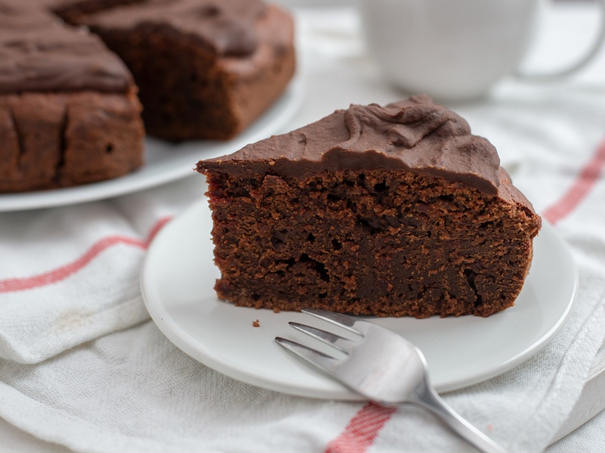 Teller mit einem Stück Rote-Bete-Kuchen auf weißem Tischtuch mit roten streifen