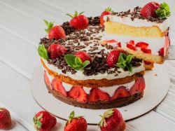 Yogurette-Torte, auf einer Platte serviert. Einige Erdbeeren liegen als Deko daneben.