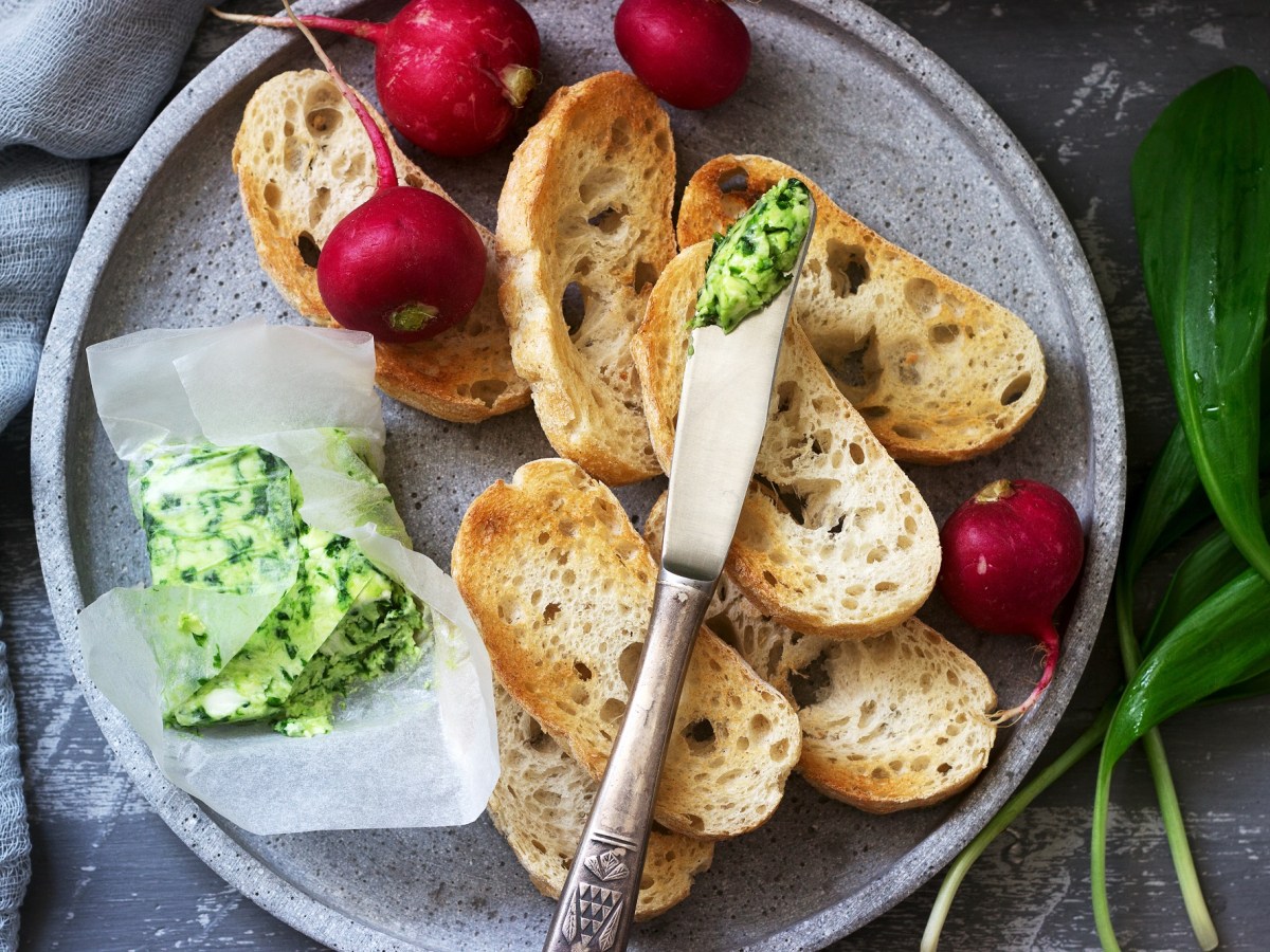 Ein Teller mit gerösteten Brotscheiben, Radieschen und Bärlauchbutter