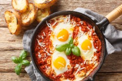 Eine Pfanne mit pochierten Eiern im Fegefeuer aus einer roten Tomatensoße.