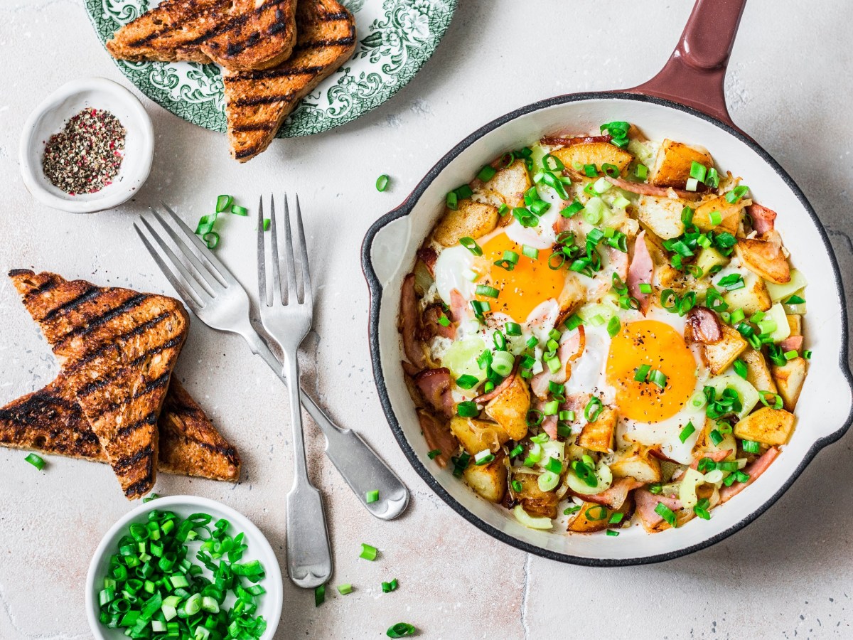 Eine Pfanne gefüllt mit Kartoffelpfanne mit Spiegelei.