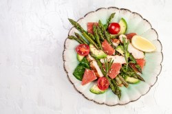 Spargel-Grapefruit-Salat mit Hähnchenbrust auf einem mintgrünen Teller.