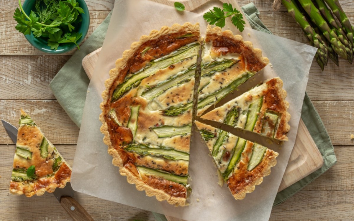 Eine Spargel-Quiche in der Draufsicht, aus der mehrere Stücke geschnitten wurden.