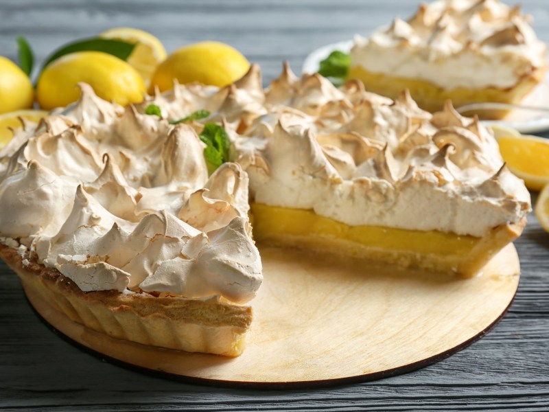 Der Zitronen-Käsekuchen mit Baiser auf einem dekorierten Tisch.