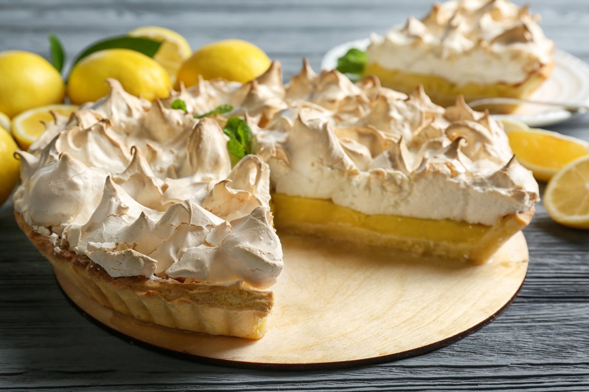 Der Zitronen-Käsekuchen mit Baiser auf einem dekorierten Tisch.