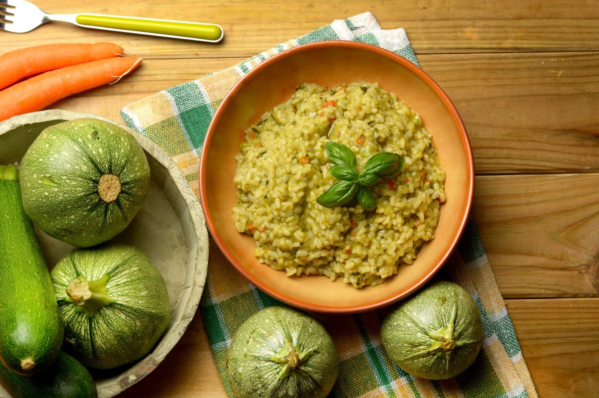 Ein Teller Zucchini-Risotto auf einem dekorierten Tisch.