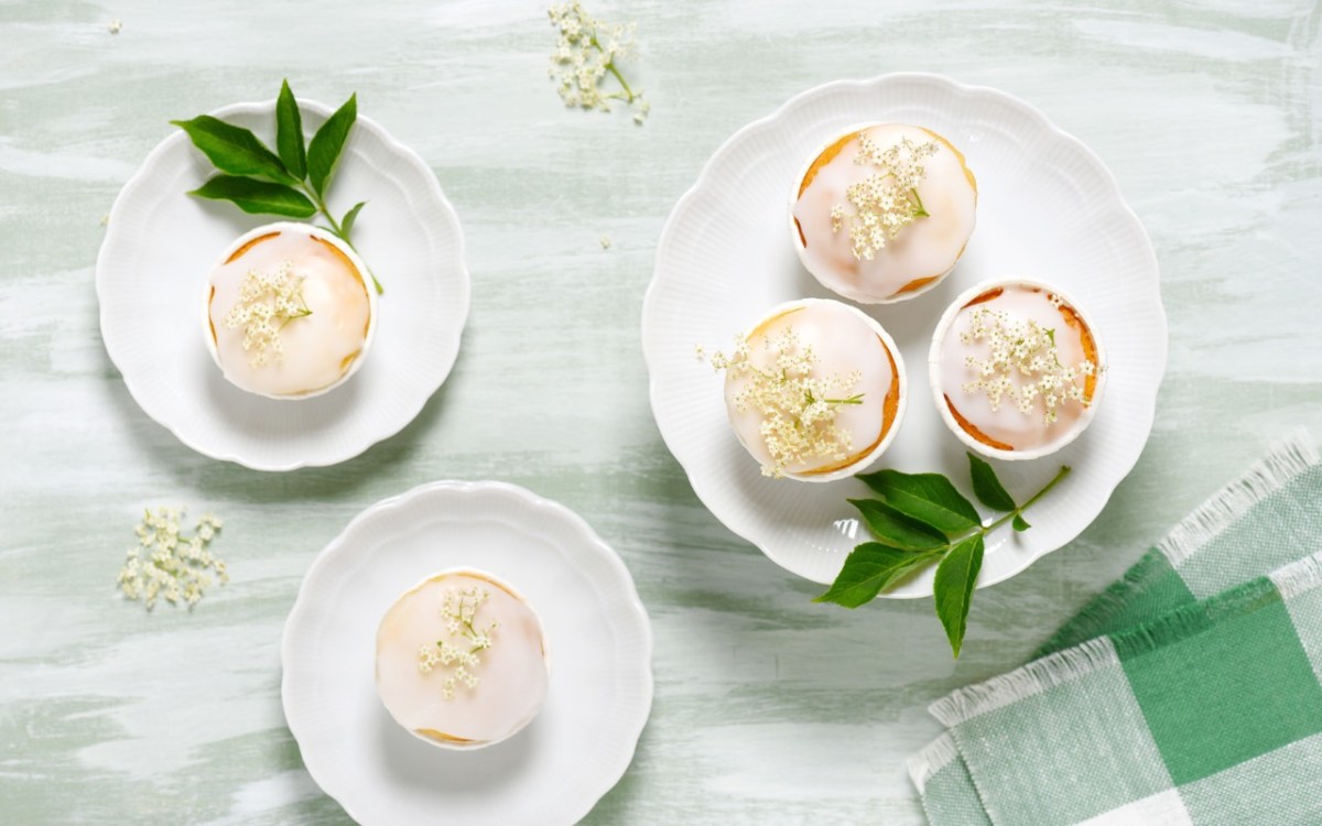 Holunderblüten-Cupcakes auf Tellern, in der Draufsicht.