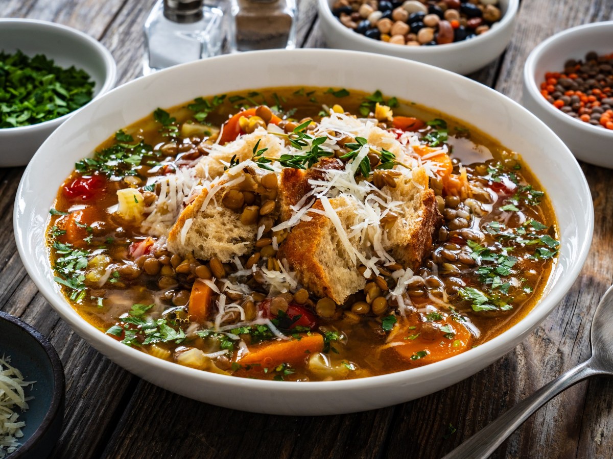 Ein Teller Linsensuppe mit Parmesan und Croûtons.