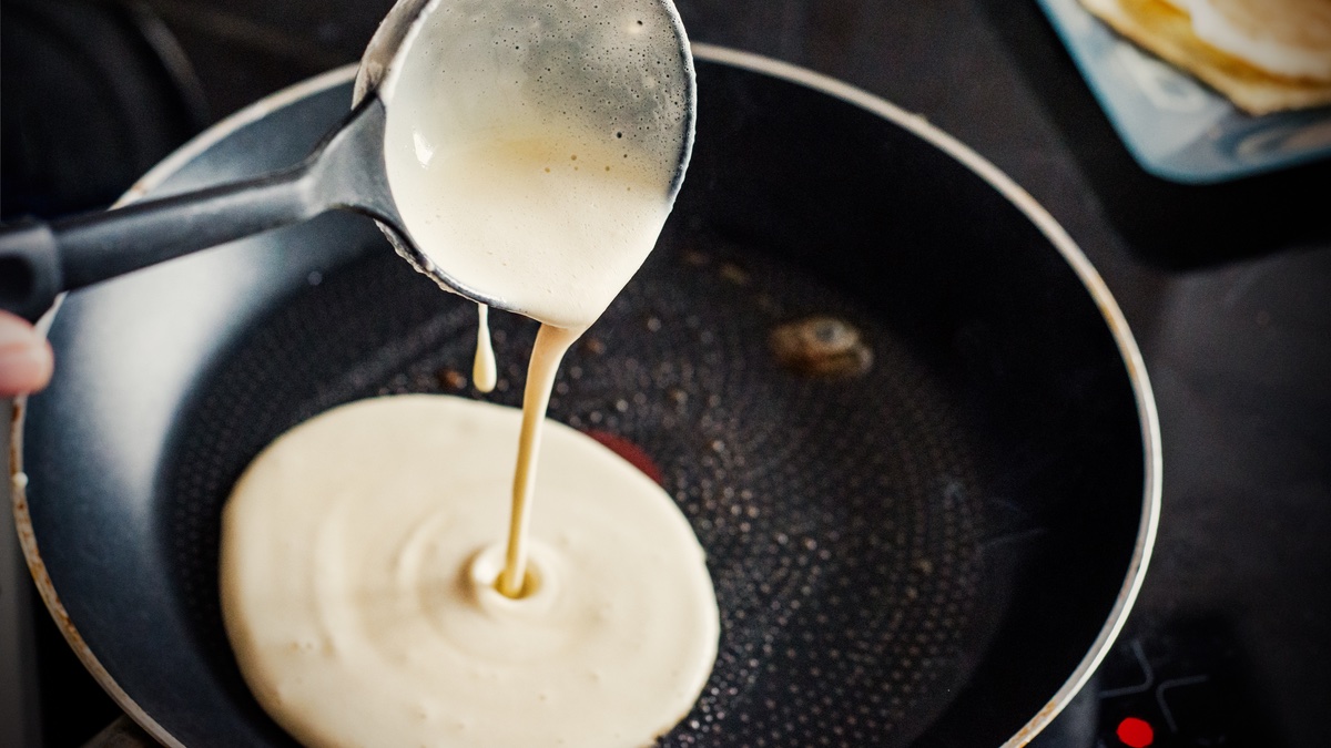 Pfannkuchen, Crêpes, Pancakes: Pfannkuchenteig in der Pfanne.