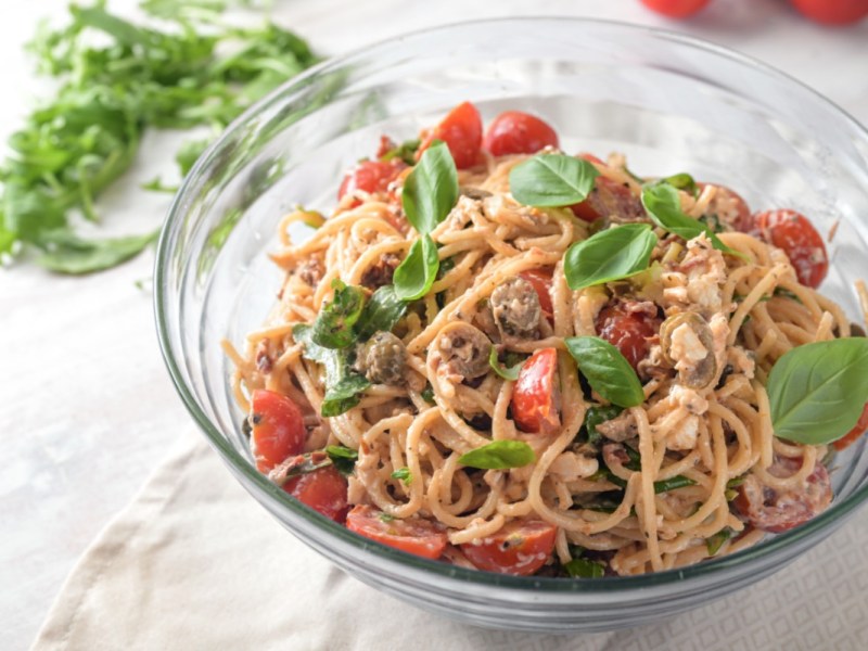 Ein Schüssel Spaghettisalat mit cremigem Dressing in der Draufsicht.